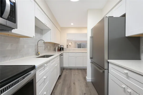 a kitchen with white cabinets and appliances