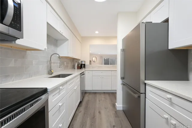a kitchen with white cabinets and appliances