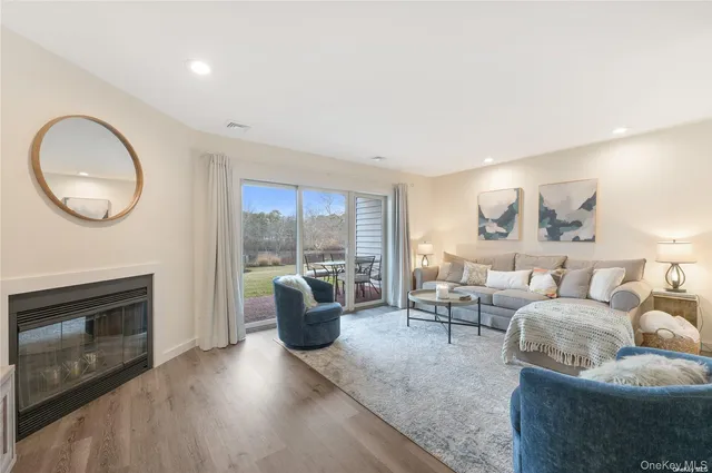 a living room with furniture a fireplace and a floor to ceiling window