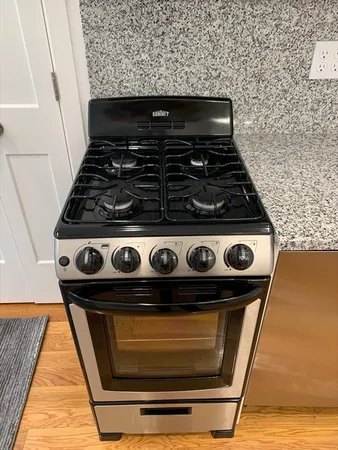 a stove top oven sitting inside of a kitchen