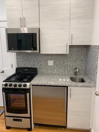 a kitchen with stainless steel appliances granite countertop a sink stove and microwave