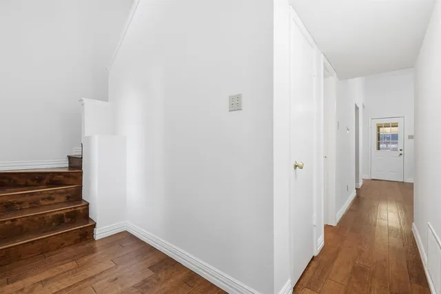 a view of a hallway with wooden floor and entryway