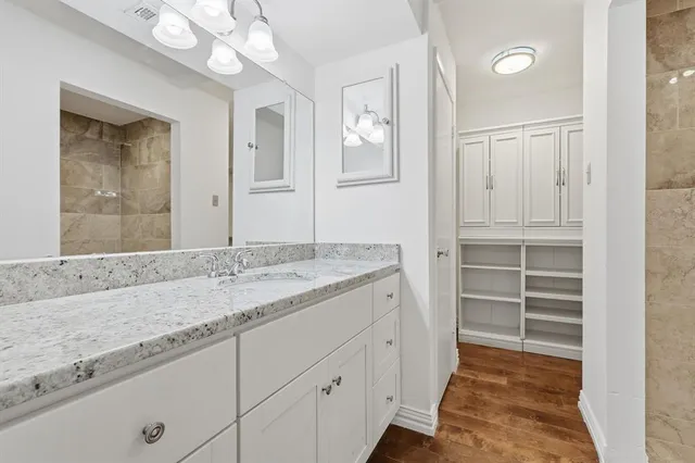 a bathroom with a granite countertop sink and a mirror