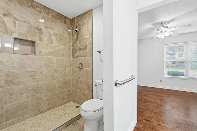 a bathroom with a granite countertop toilet a sink and shower