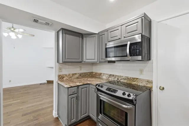 a kitchen with stainless steel appliances granite countertop a stove microwave and sink