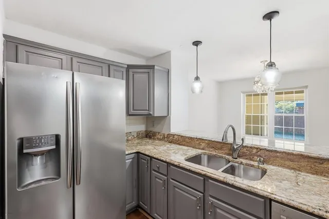 a kitchen with stainless steel appliances granite countertop a refrigerator and a sink