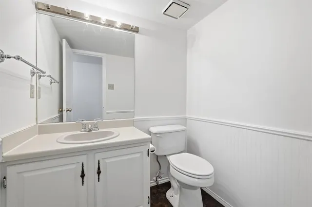 a bathroom with a sink toilet and a mirror