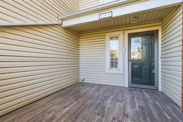 a view of a porch with a door and wooden floor