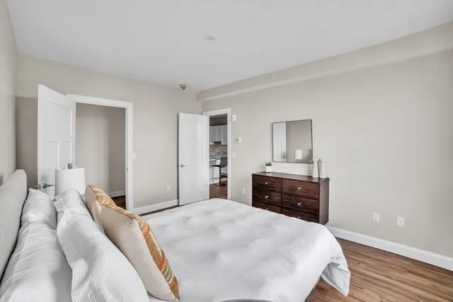 a bedroom with a bed and wooden floor