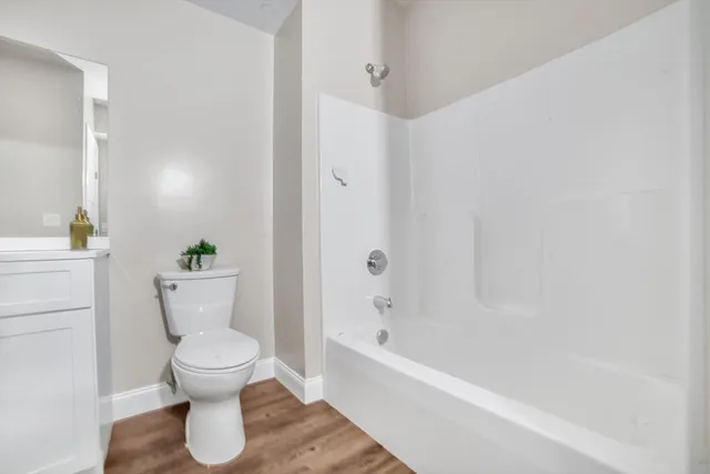 a white toilet sitting next to a bathtub