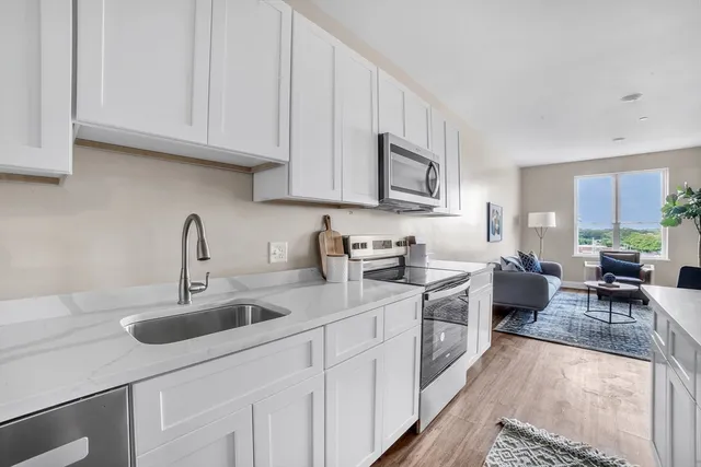 a kitchen with white cabinets and white appliances