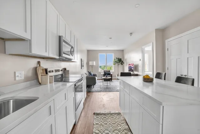 a kitchen with stainless steel appliances granite countertop a sink stove and cabinets
