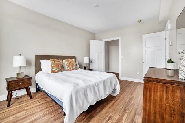 a bedroom with a bed and wooden floor