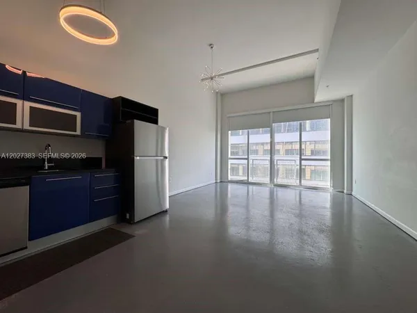 a kitchen with granite countertop a refrigerator stove and cabinets