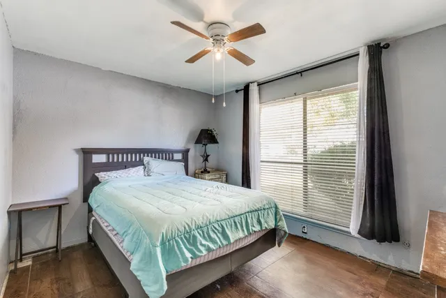 a bedroom with a bed and a large window
