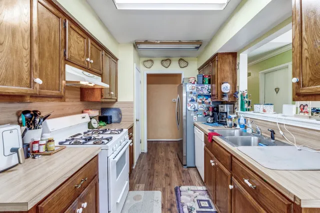 a kitchen with stainless steel appliances granite countertop a sink stove and refrigerator