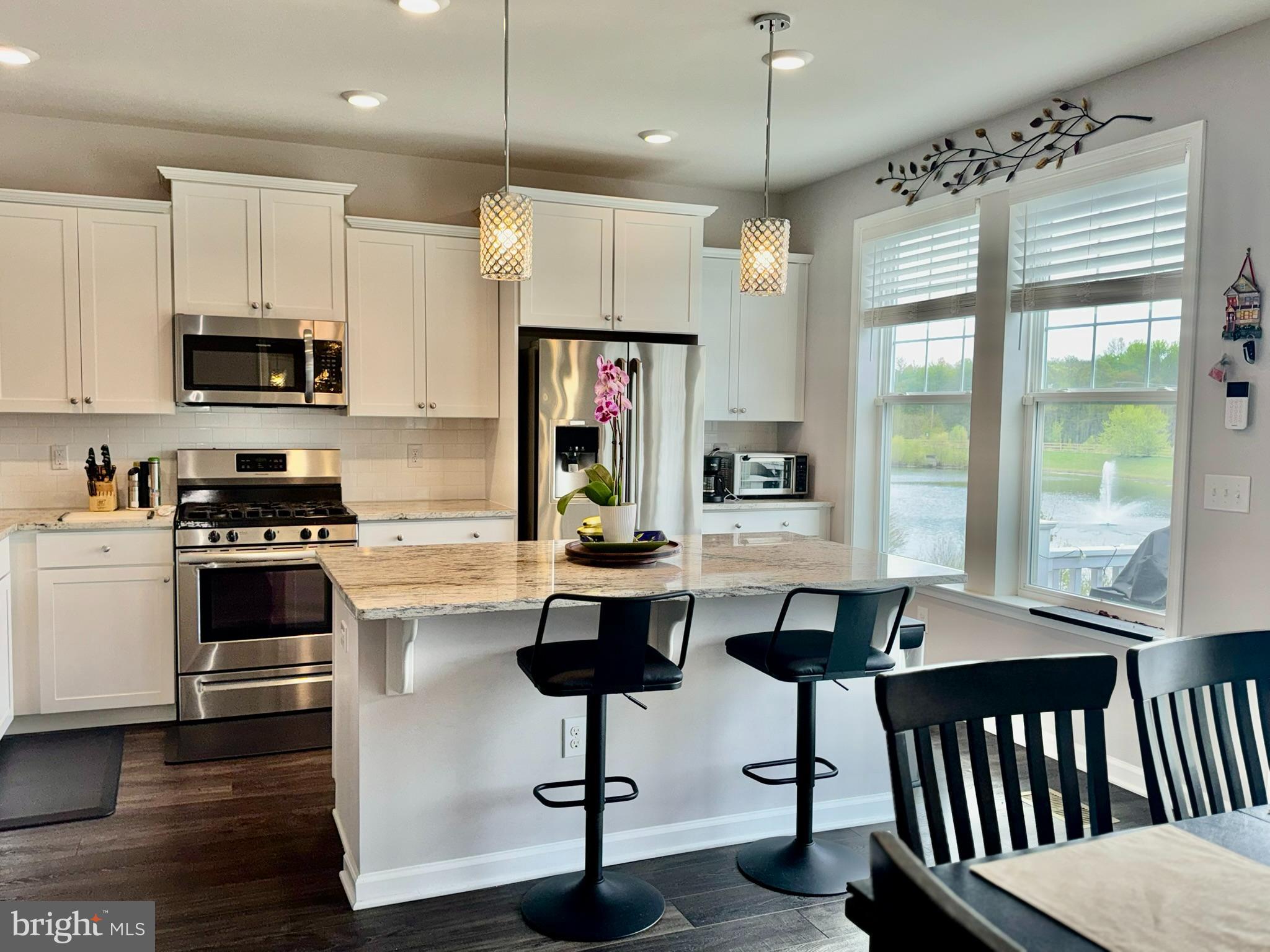 15 Turin Way Mount Laurel, NJ 08054 - Photo 8 of 36 a kitchen with stainless steel appliances kitchen island granite countertop a stove a sink a refrigerator and a dining table with wooden floor