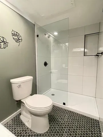 a bathroom with a toilet and a shower