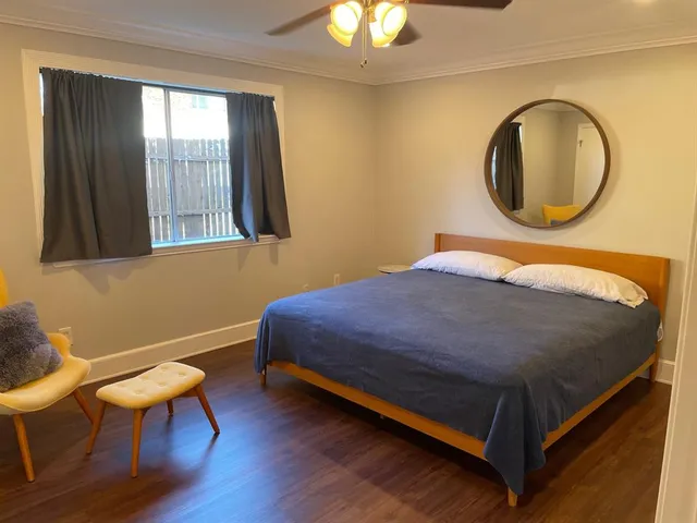 a bedroom with a bed and a painting on the wall