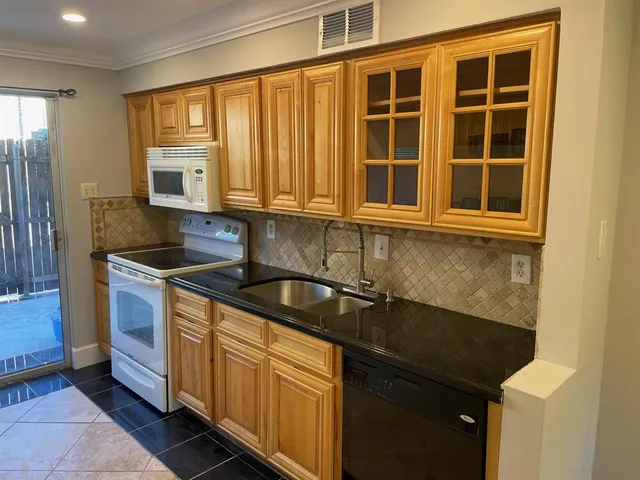 a kitchen with granite countertop cabinets sink and window