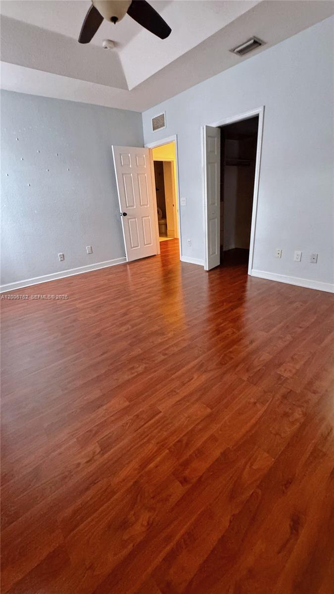 15810 Southwest 40th Street, Unit 57 Miramar, FL 33027 - Photo 14 of 20 an empty room with wooden floor and chandelier fan
