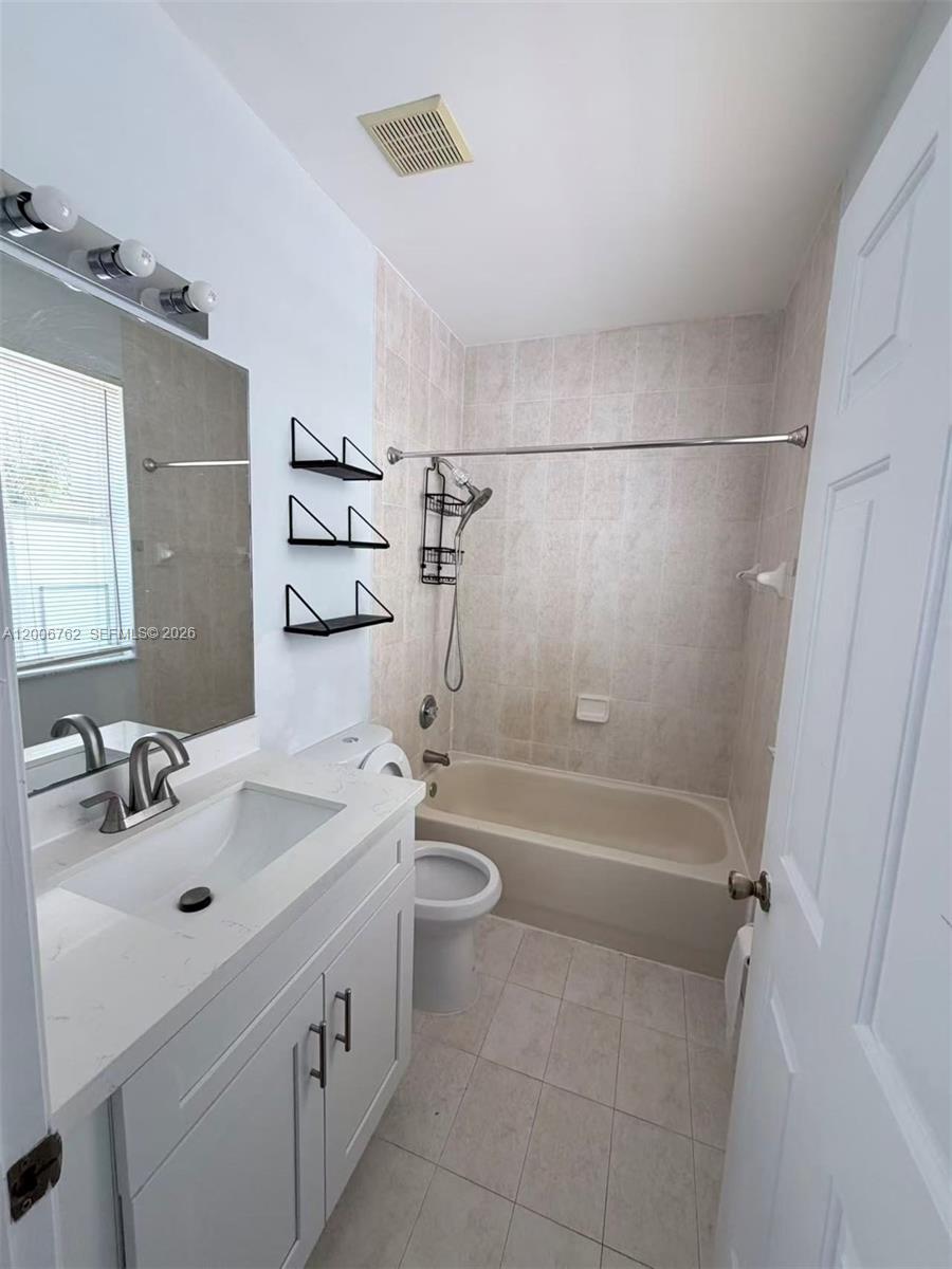 15810 Southwest 40th Street, Unit 57 Miramar, FL 33027 - Photo 18 of 20 a bathroom with a tub sink toilet and a mirror