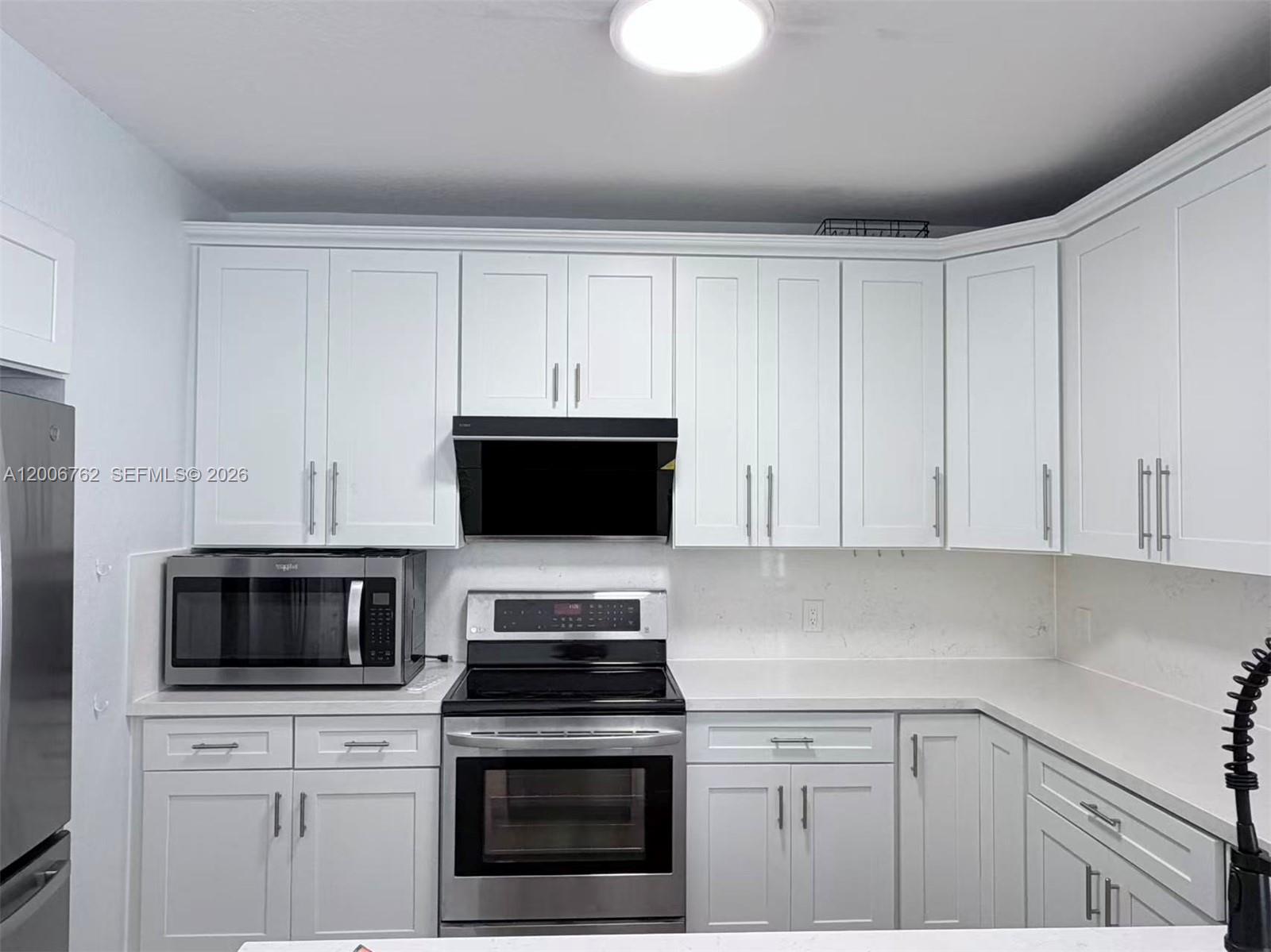 15810 Southwest 40th Street, Unit 57 Miramar, FL 33027 - Photo 10 of 20 a kitchen with white cabinets and stainless steel appliances
