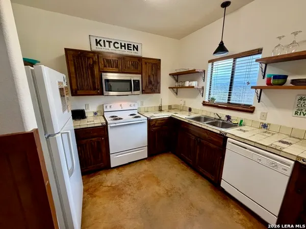 a kitchen with stainless steel appliances granite countertop a stove refrigerator sink and microwave