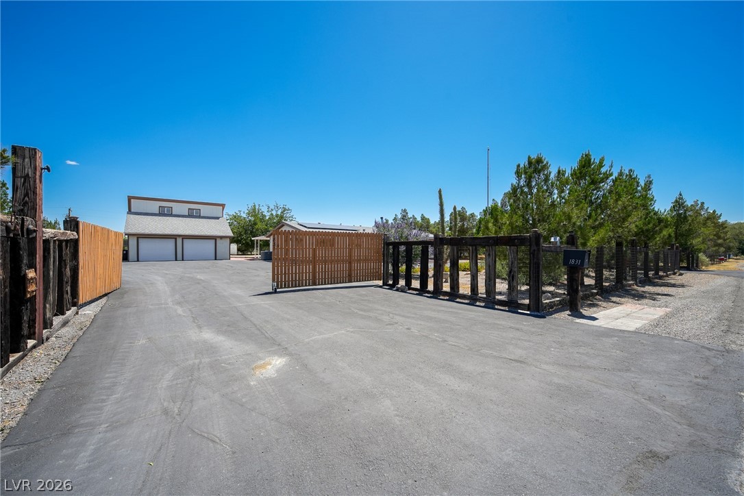 1831 West Horn Road Pahrump, NV 89048 - Photo 28 of 59 A private gated driveway leads to a spacious two-car garage with an additional living area above.