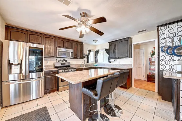 a kitchen with granite countertop a table chairs stainless steel appliances and cabinets