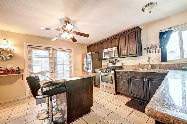 a kitchen with granite countertop cabinets stainless steel appliances a sink and a dining table