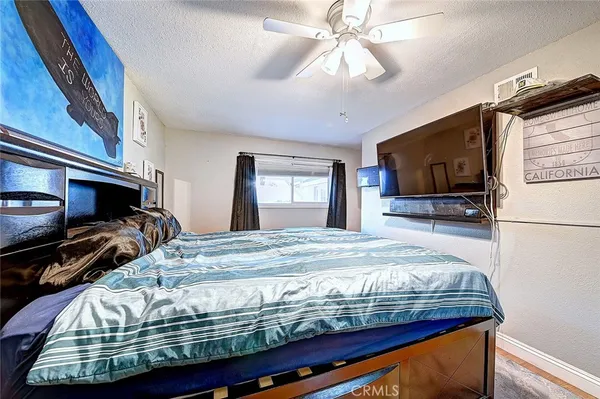 a bed sitting in a bedroom and flat screen tv