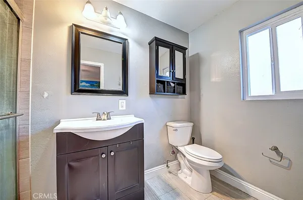 a bathroom with a toilet a sink and mirror