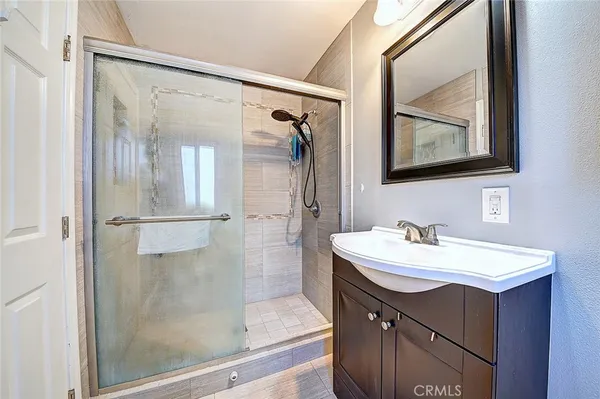 a bathroom with a sink a mirror a vanity and a shower