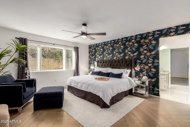 a spacious bedroom with a bed and a flat screen tv