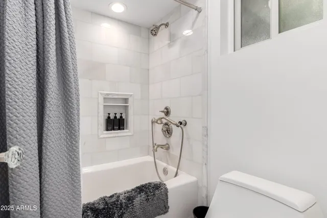 a bedroom with a bed and painting on the wall