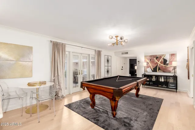a backyard of a house with dining table and chairs with plants
