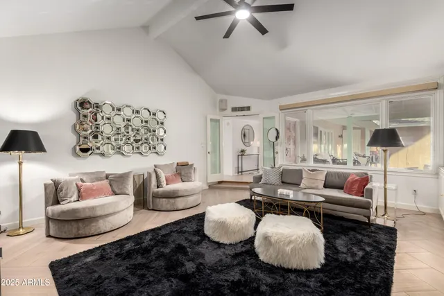 a living room with furniture a flat screen tv and a chandelier