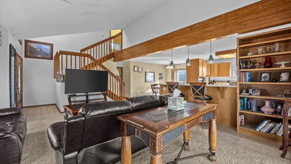 a dining room with furniture a chandelier and wooden floor