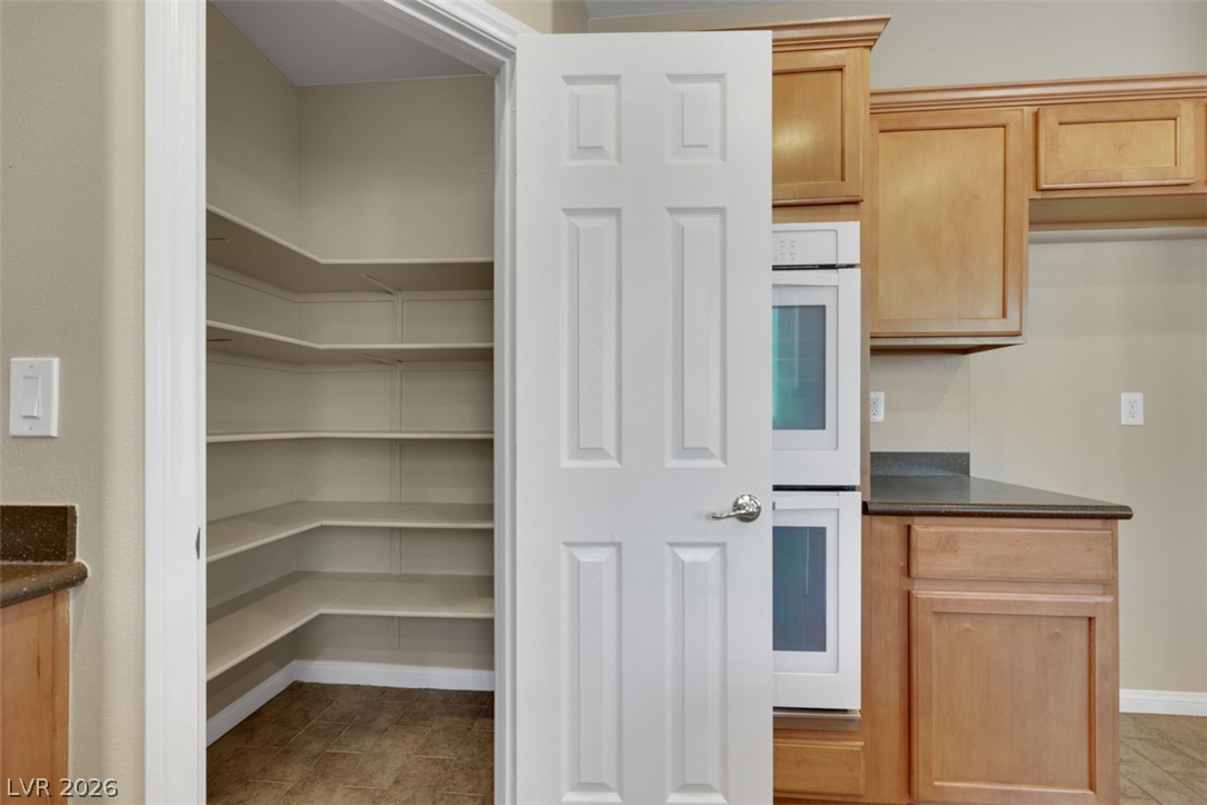10328 Hawk Ravine Street Las Vegas, NV 89178 - Photo 17 of 55 Organized pantry with ample shelving complements this well-appointed kitchen.