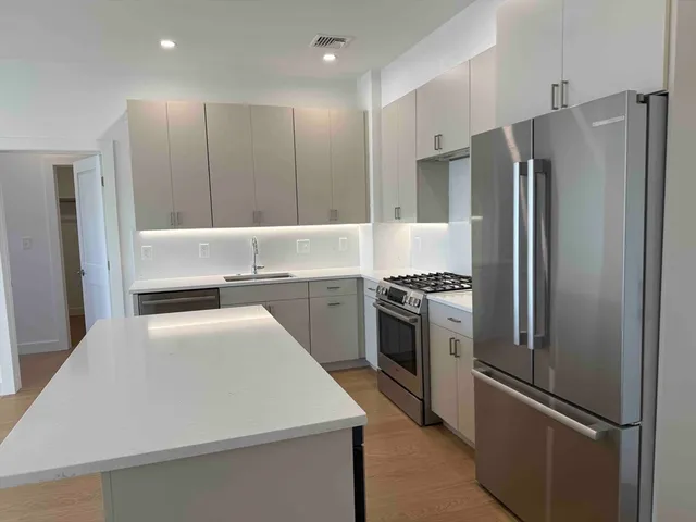 a kitchen with stainless steel appliances a refrigerator sink and stove