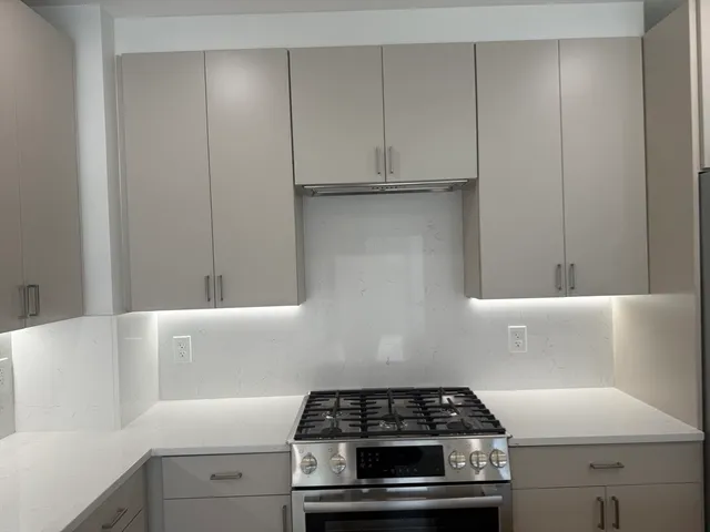 a kitchen with a stove and white cabinets
