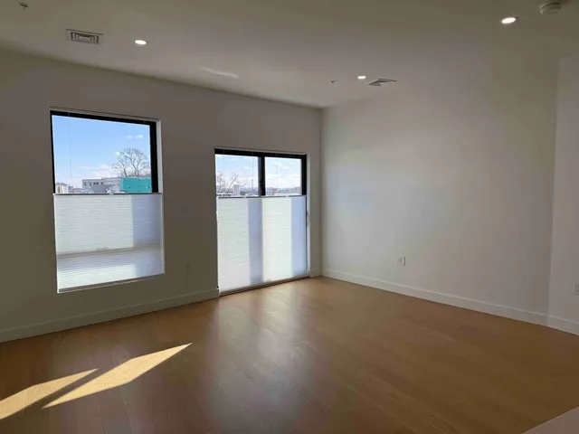 a view of a hallway with wooden floor and cabinet