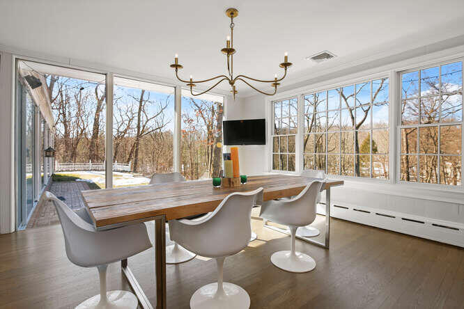 67 Hickok Road New Canaan, CT 06840 - Photo 18 of 56 a dining room with furniture a chandelier and wooden floor