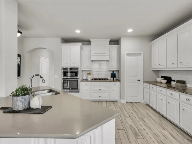 a kitchen with stainless steel appliances granite countertop a sink a stove and cabinets