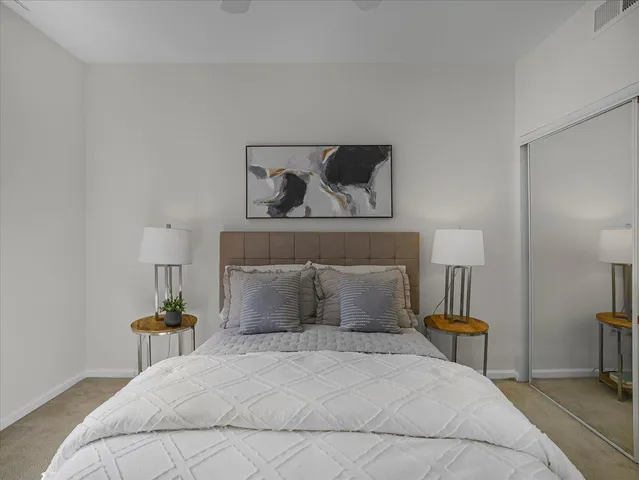 a bedroom with a bed and a potted plant