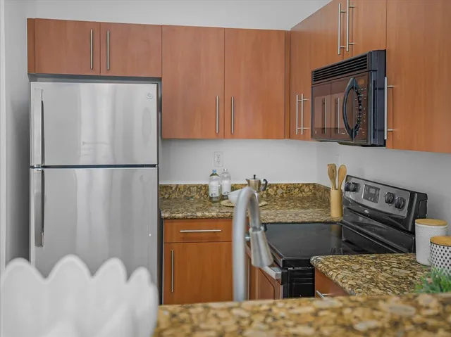 a kitchen with stainless steel appliances granite countertop a refrigerator sink and cabinets