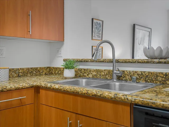 a kitchen with granite countertop a sink and cabinets
