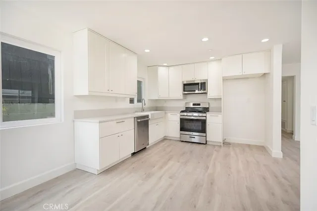 a kitchen with a refrigerator a stove top oven and a center island