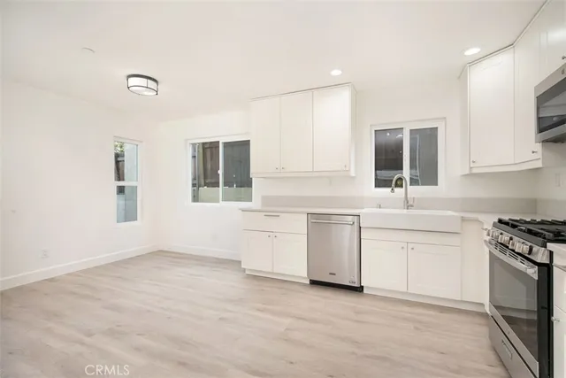a kitchen with granite countertop white cabinets and white appliances